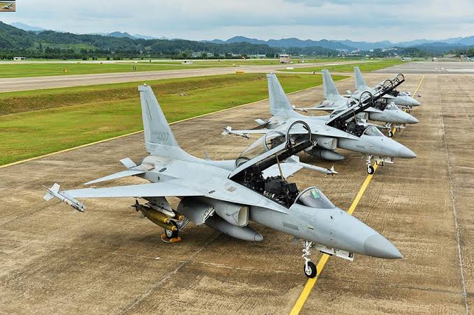 Nigerian Air Force fighter jets lined up on the flight line with cockpits open